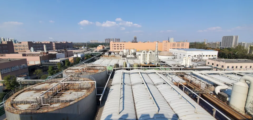 Industrial wastewater treatment facility with tanks, covered basins, and process pipework