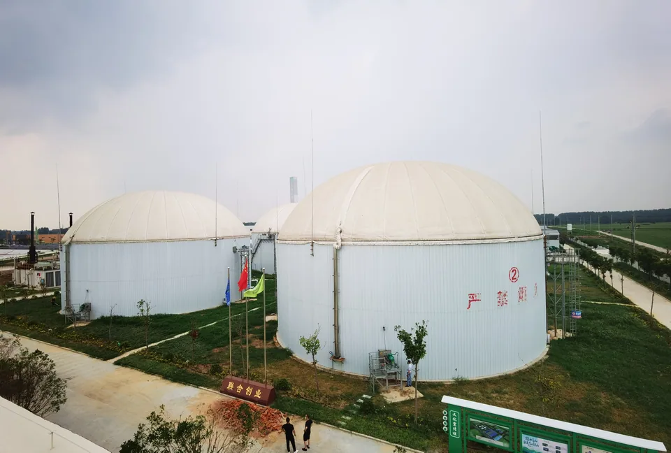 Instalasi biogas dengan beberapa digester anaerobik beratap membran, peralatan pembangkit listrik, platform perpipaan, serta jalan akses dan area hijau
